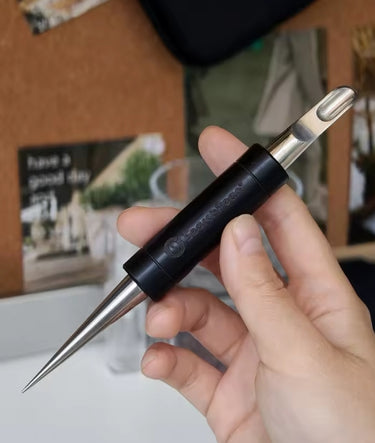 Hand holding a multi-tool with different attachments against a blurred indoor background